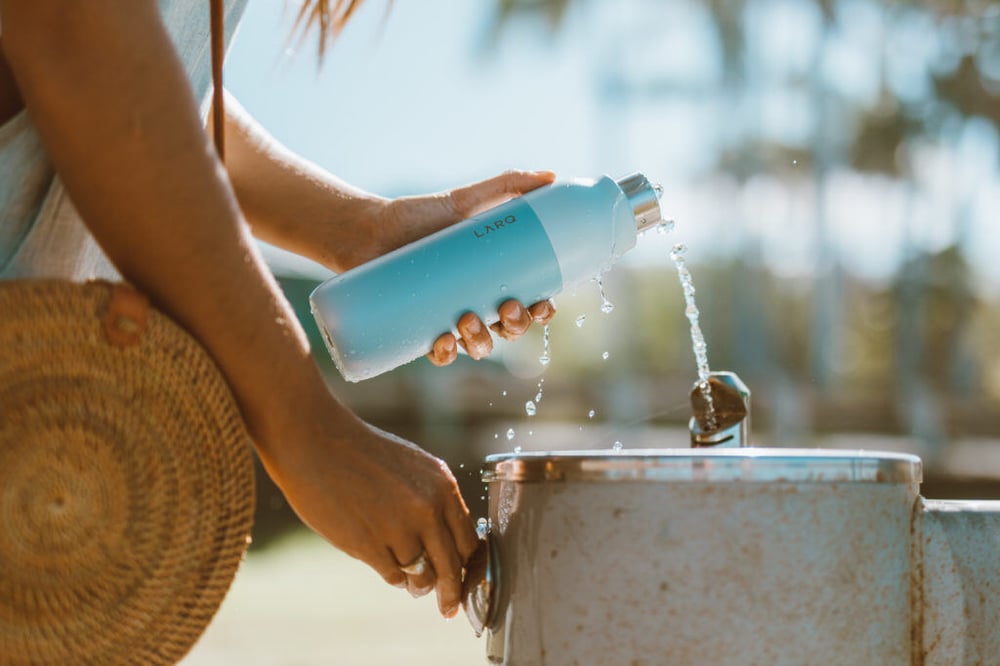 A traveller filling up a reusable water bottle on the ship